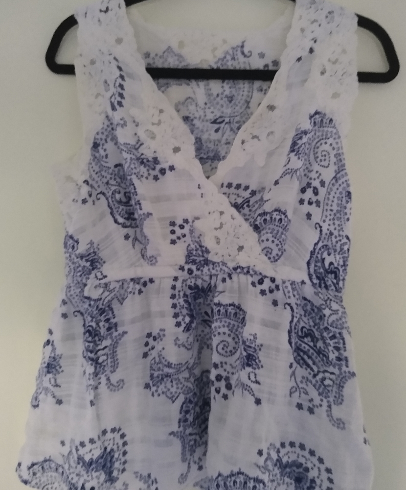 Cabi Sleeveless mock-wrap top.